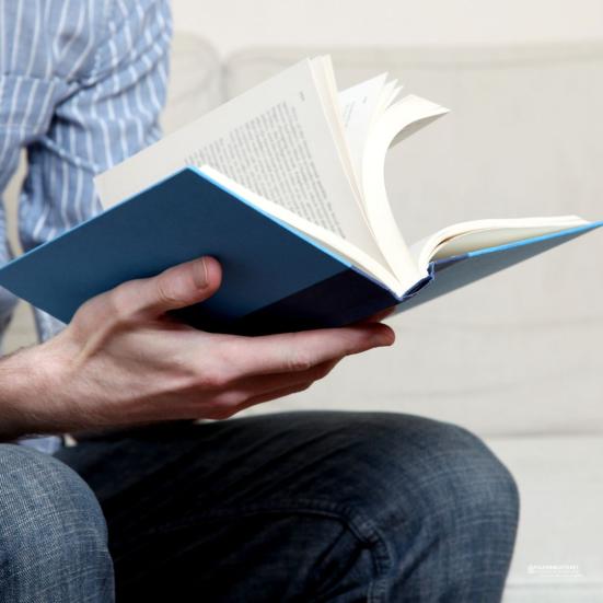 Mand med opslået bog i hænderne